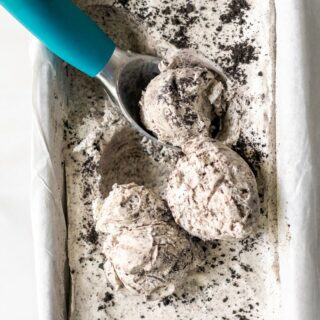 close up of cookies and cream ice cream in a pan with a scooper