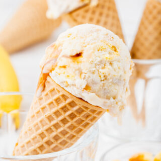Banoffee pie ice cream in 3 sugar cones, placed in glass ice cream dishes.