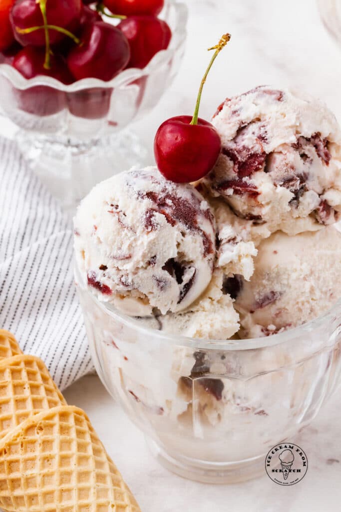 cherry vanilla ice cream in a bowl topped with a cherry