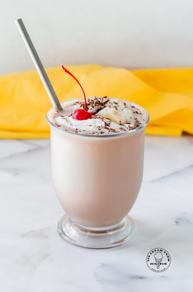 chocolate banana milkshake in a glass with a metal straw