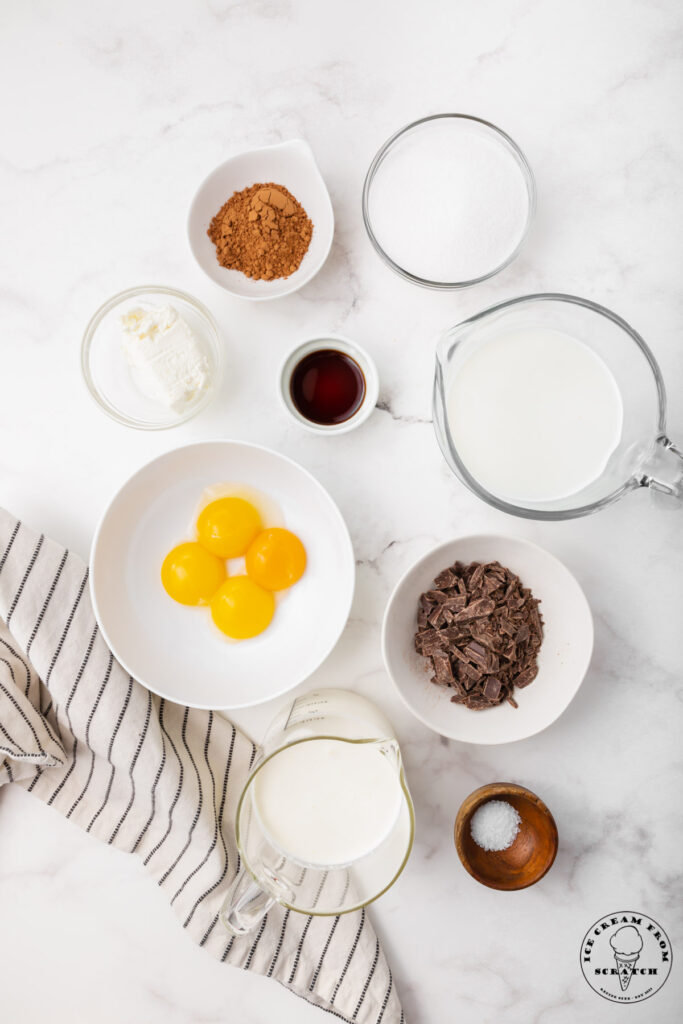 ingredients needed to make french silk ice cream, each in separate bowls on a marble countertop