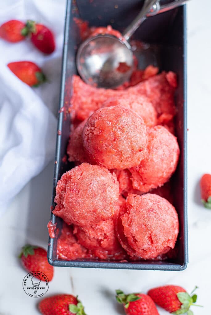 scoops of strawberry sorbet in a metal loaf pan