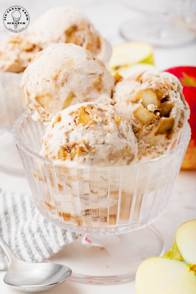 Three scoops of homemade apple pie ice cream in a glass footed ice cream dish.