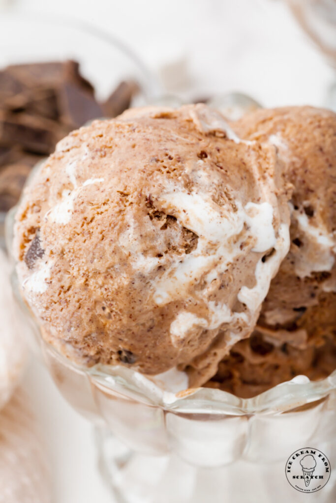Closeup of homemade chocolate marshmallow ice cream scoop, showing marshmallow swirls an dchocolate chunks.