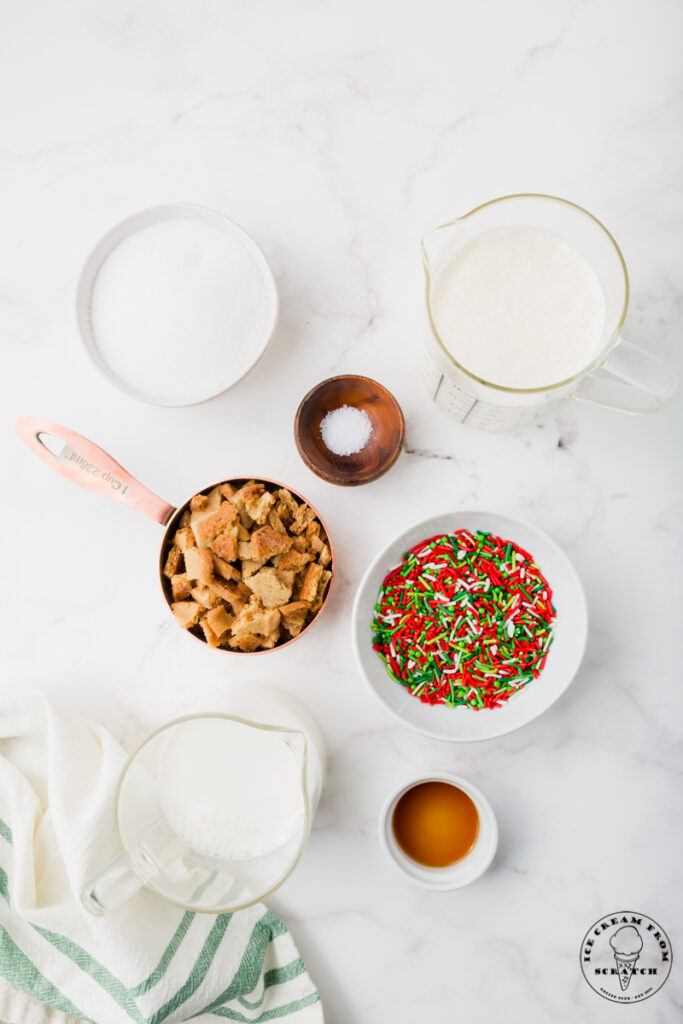 Ingredients for christmas ice cream, all in separate bowls on a marble countertop.