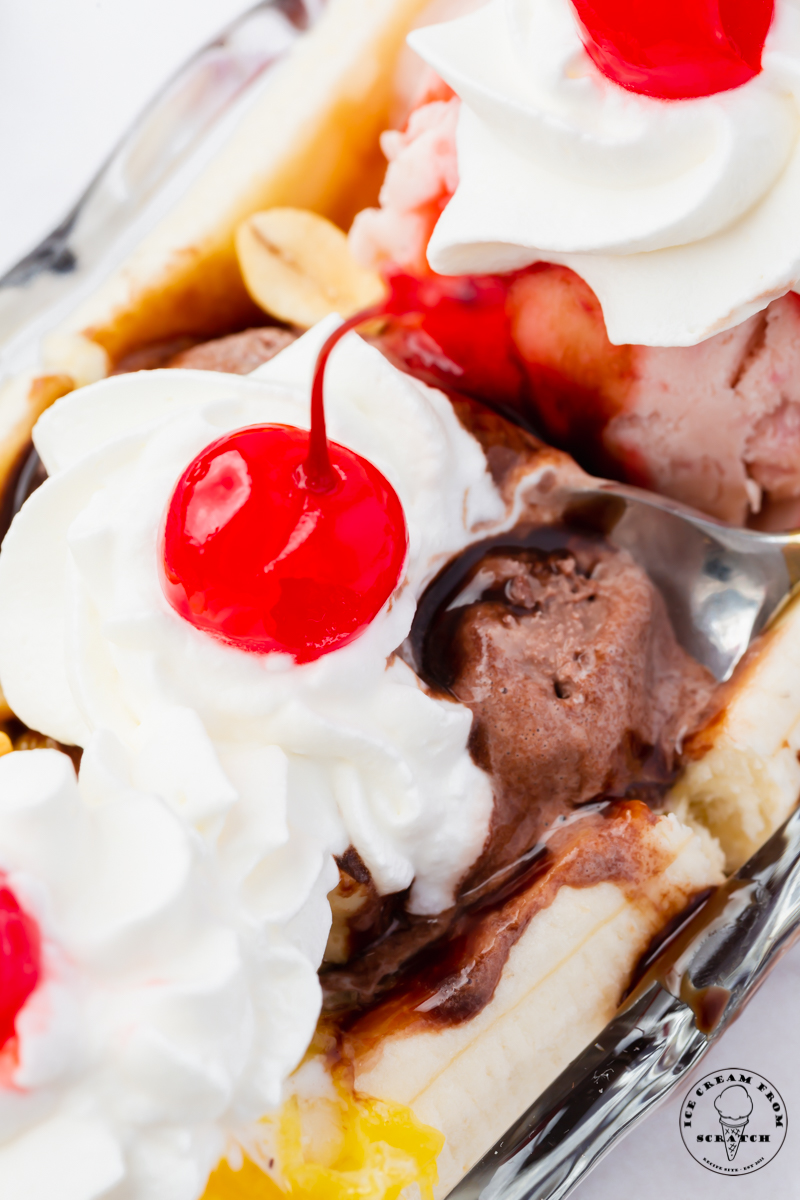 closeup view of a banana split. Bananas topped with ice cream, syrup, nuts, whipped cream and cherries