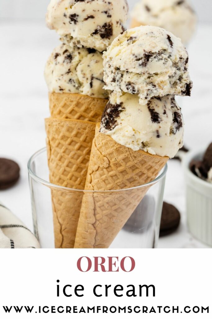 Two sugar cones with double scoops of Oreo cookies and cream ice cream held up in a glass