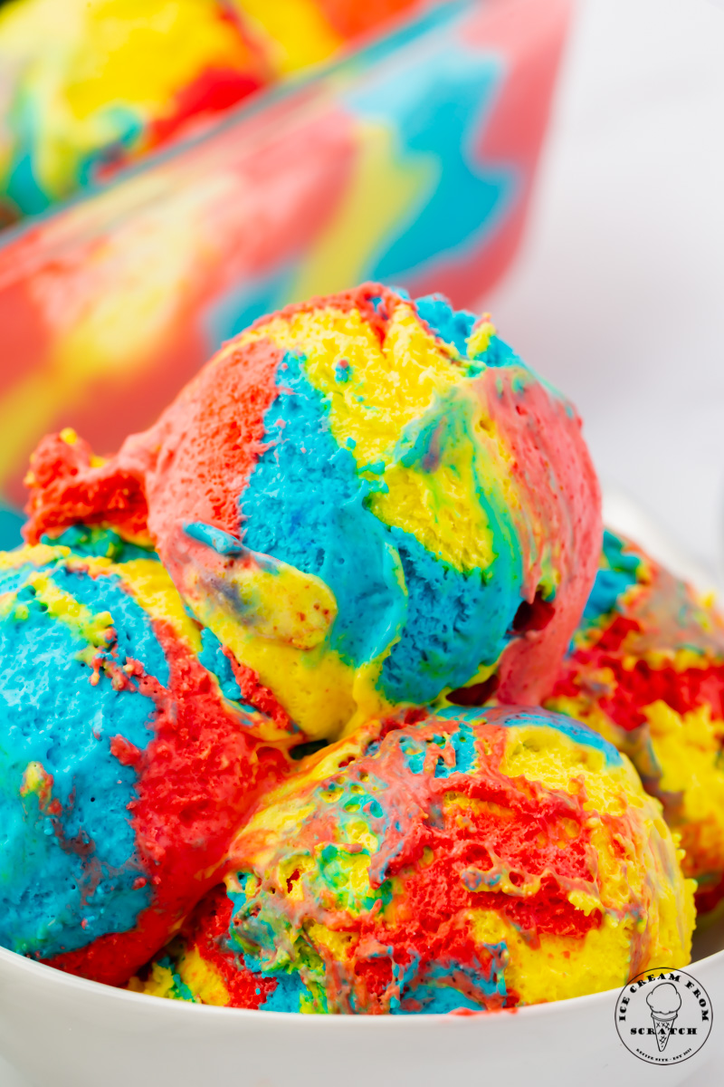 a bowl filled with scoops of red, blue, and yellow swirled superman ice cream