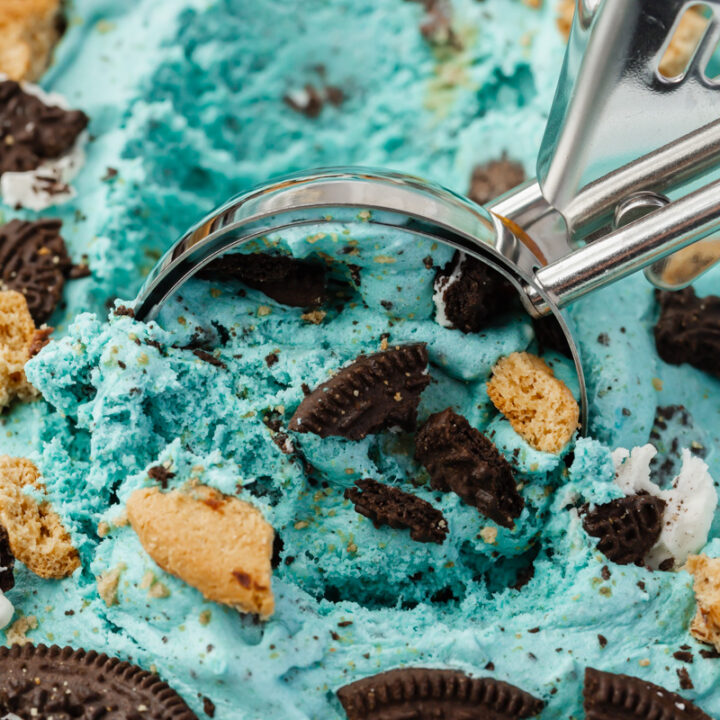 closeup view of a pan of homemade cookie monster ice cream, being scooped with a metal ice cream scoop