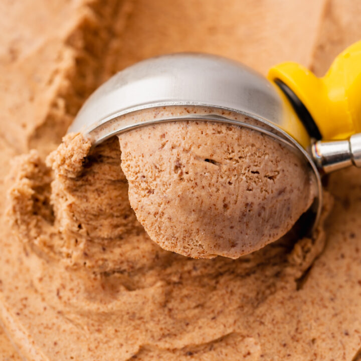 closeup view of homemade chocolate ice cream being scooped with a metal ice cream scoop.