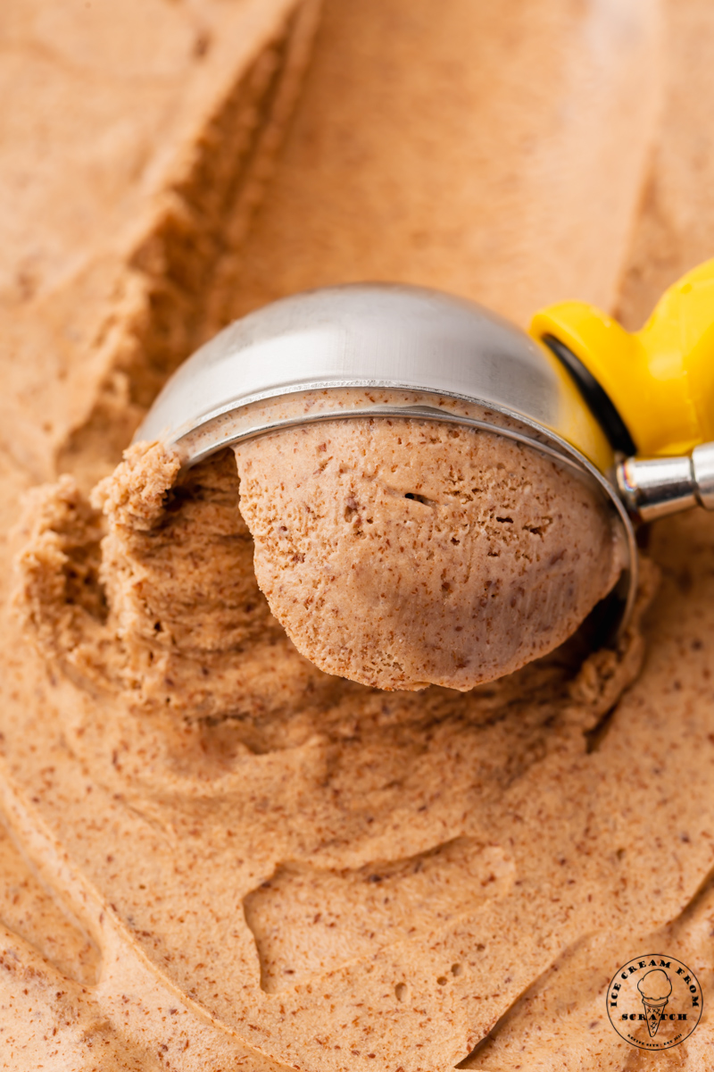 closeup view of homemade chocolate ice cream being scooped with a metal ice cream scoop.