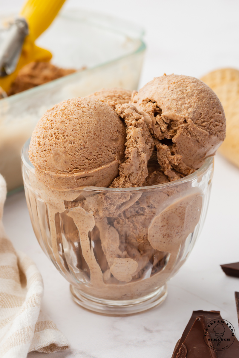 a glass dish filled with 4 scoops of chocolate ice cream.