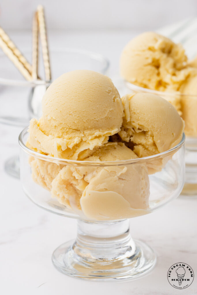 a footed glass dish with smooth sides, filled with four scoops of oat milk ice cream.