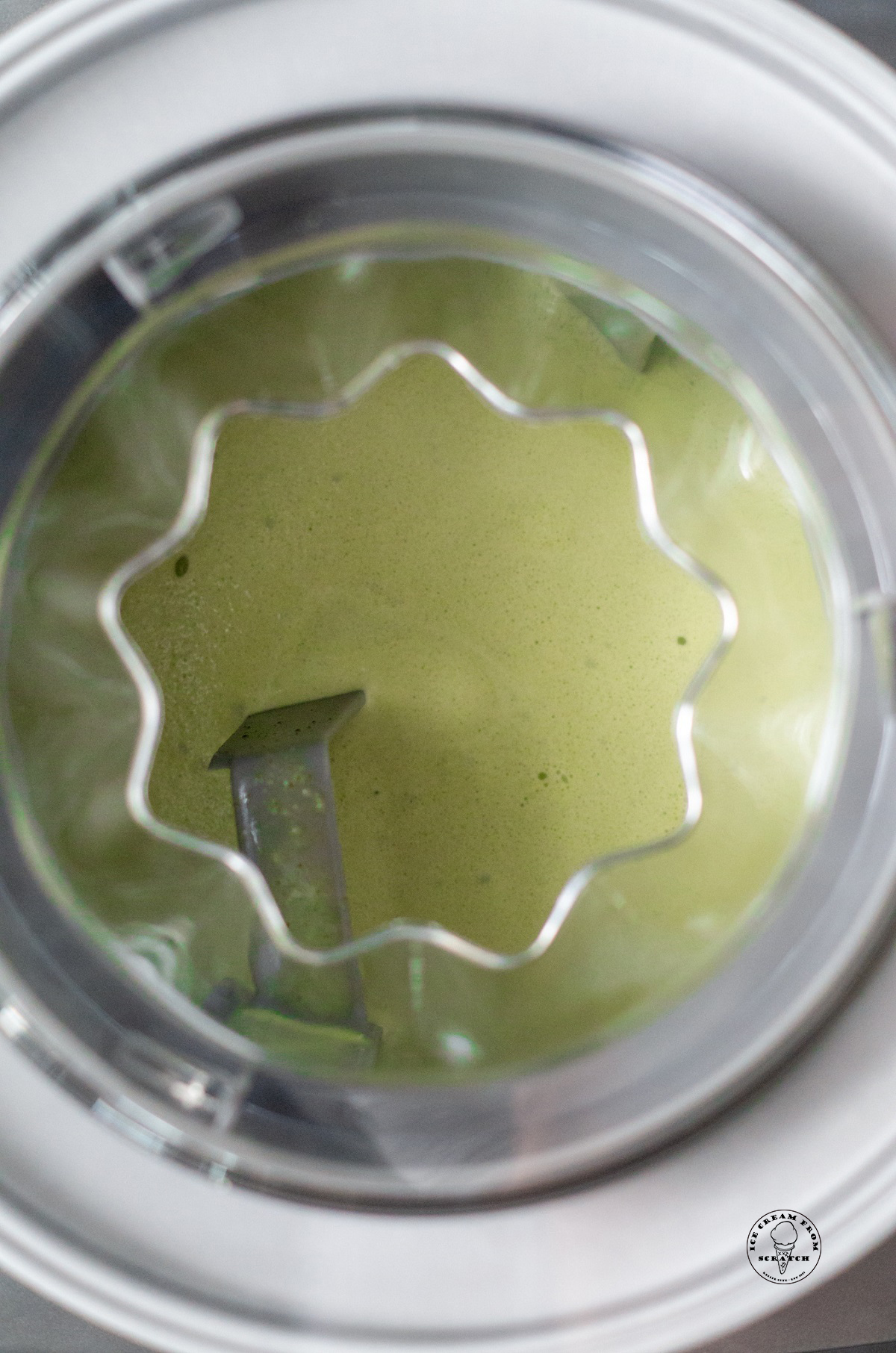 A photo of matcha ice cream churning in an ice cream maker, viewed from above