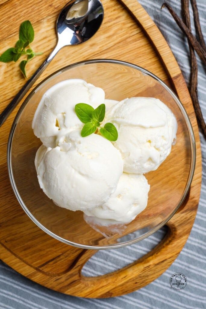 top down view of no churn vanilla ice cream in a clear bowl with mint on top