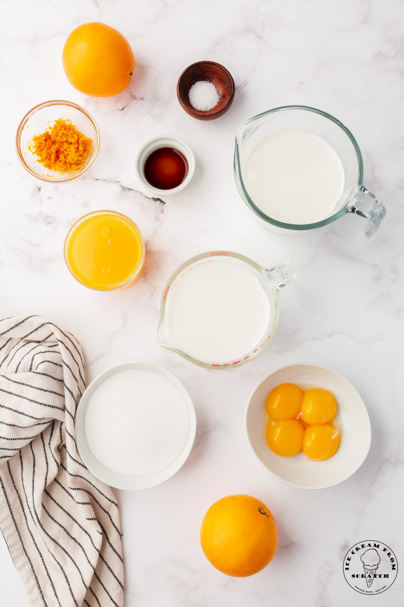 The ingredients needed to make orange ice cream from scratch, viewed from above
