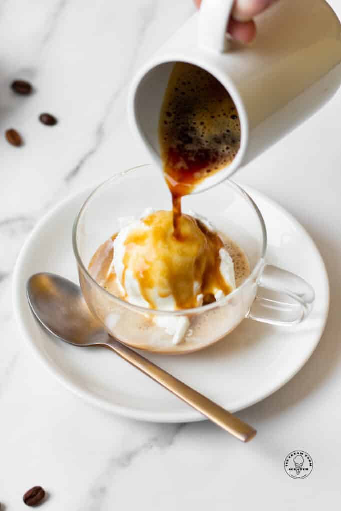 espresso being poured over a scoop of vanilla ice cream in a glass mug