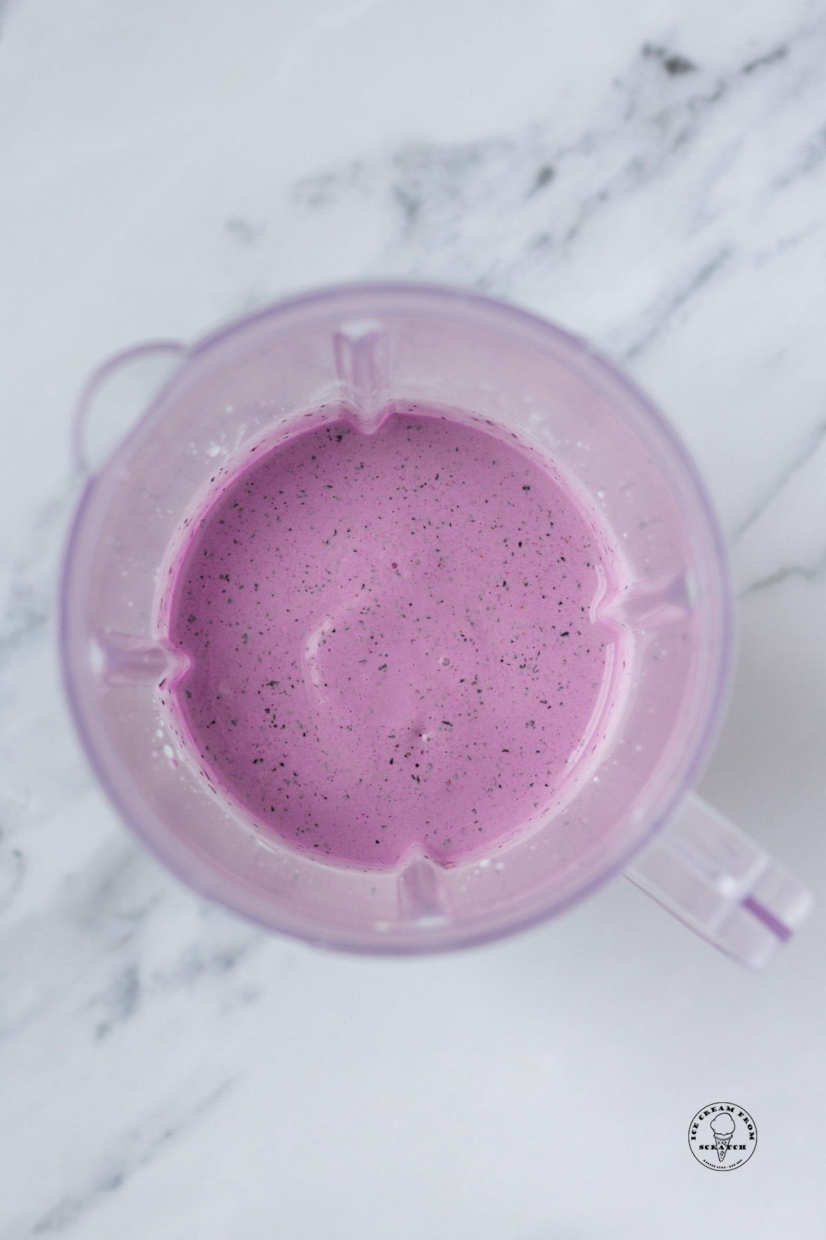 view from above of a blueberry milkshake in a blender jar