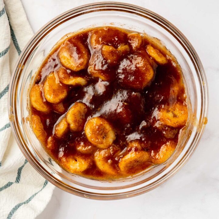 a glass bowl filled with caramelized banana slices, viewed from above.