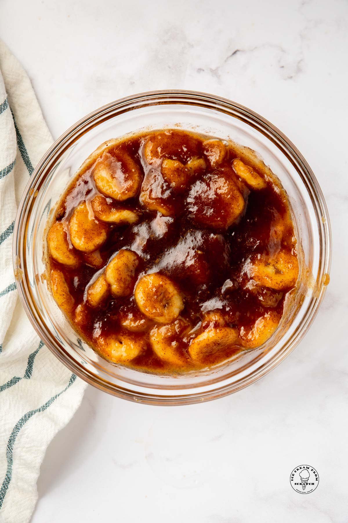 a glass bowl filled with caramelized banana slices, viewed from above.