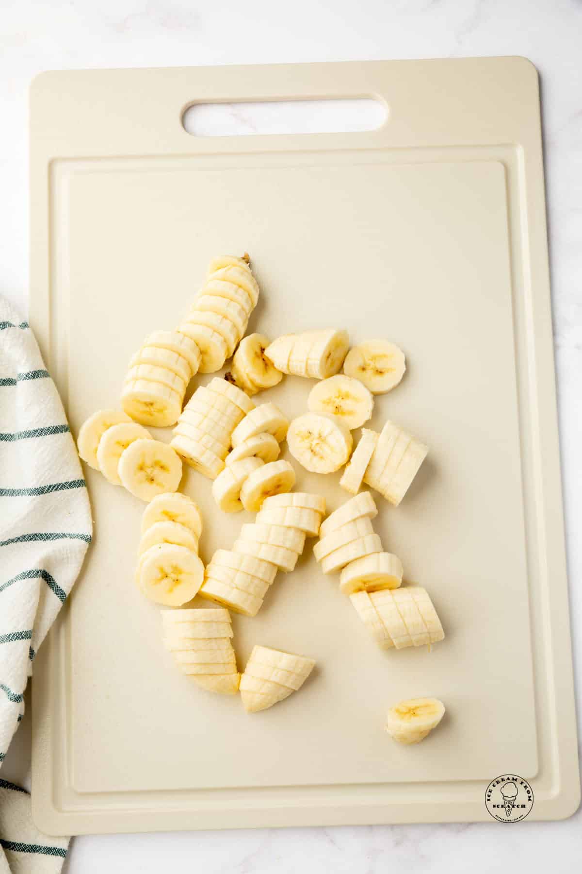 sliced bananas on an off-white cutting board