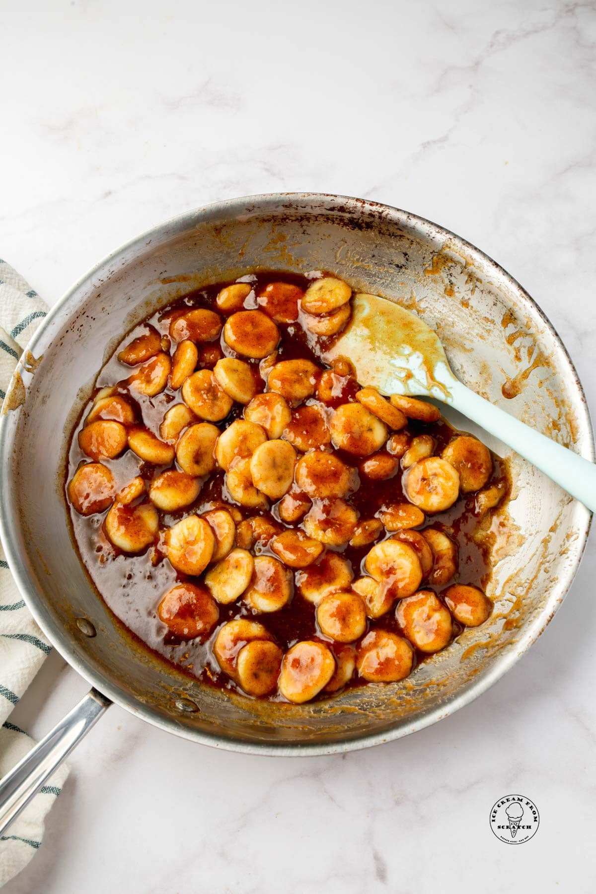 a silver frying ban filled with cooked bananas in a caramel sauce