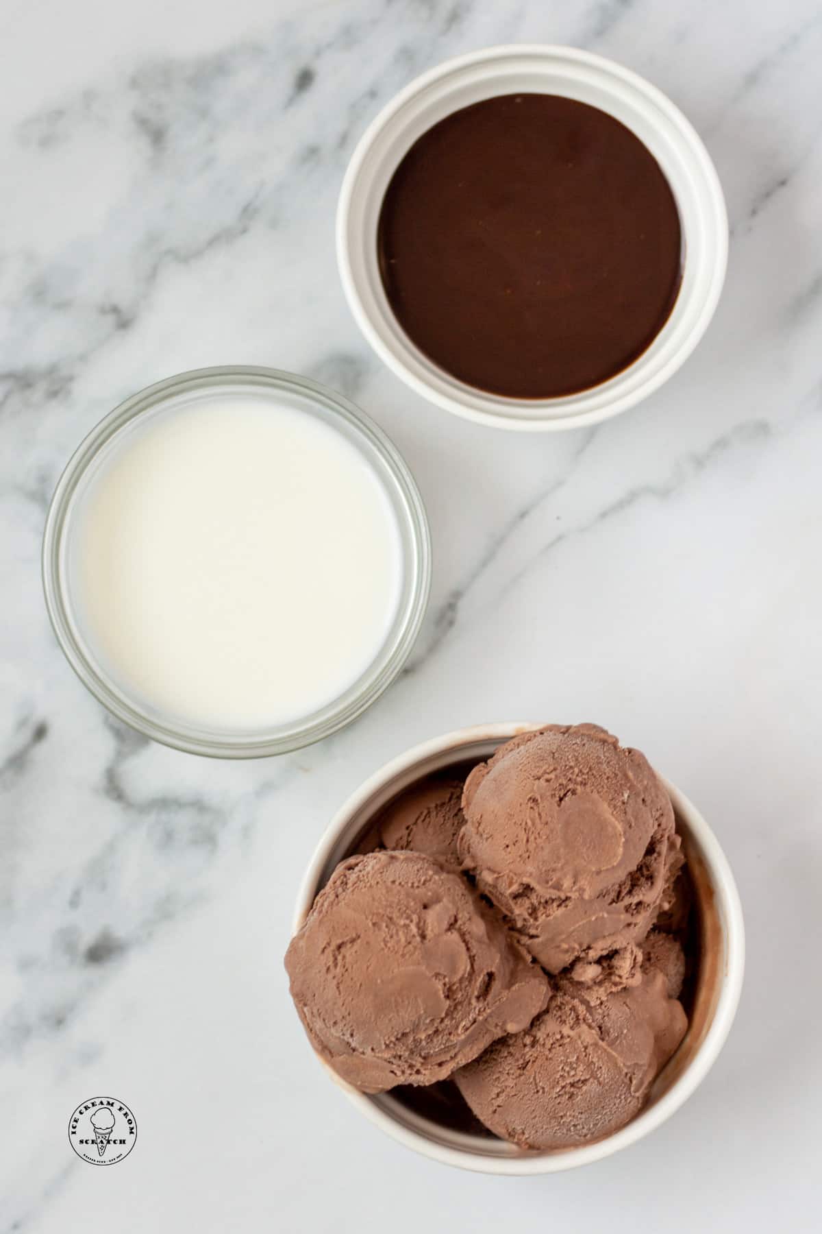 a bowl of chocolate ice cream, a bowl of milk, and a bowl of chocolate syrup