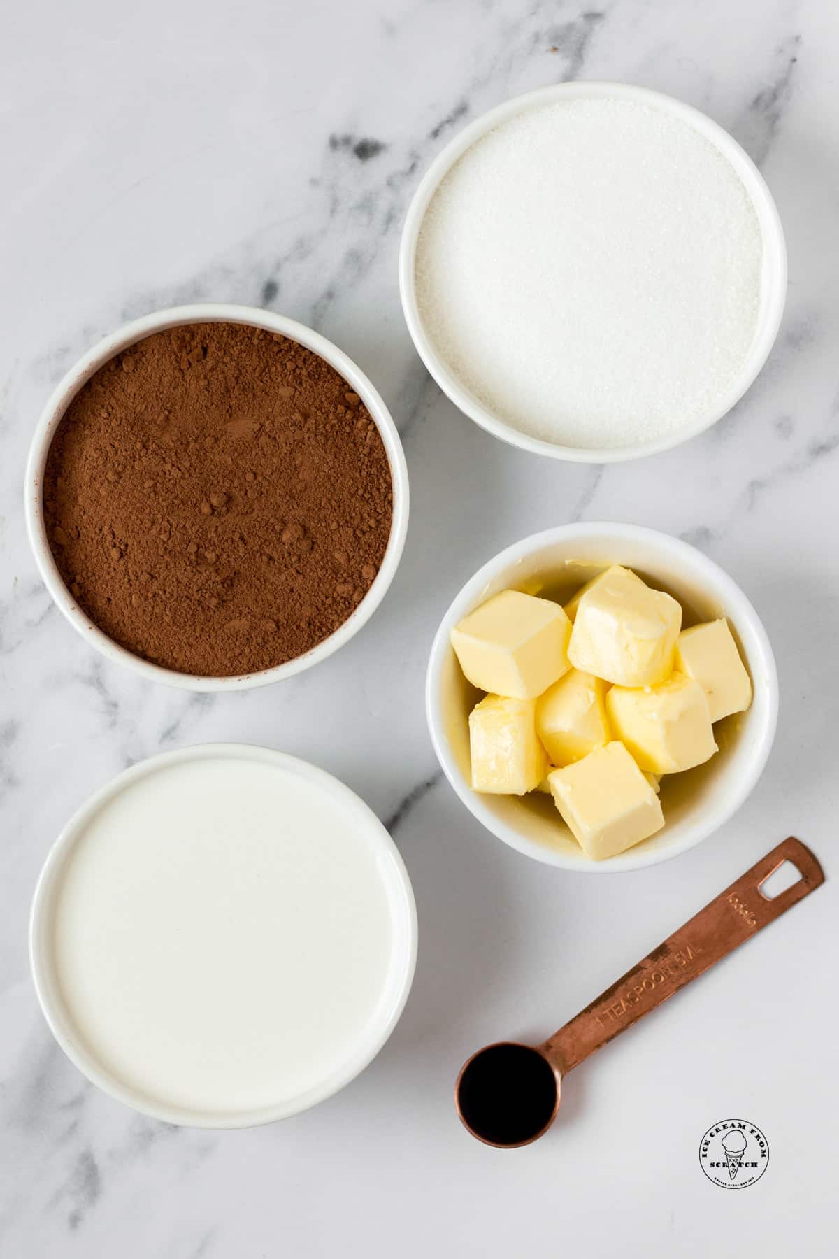 The ingredients in homemade hot fudge sauce, on a marble counter, viewed from overhead