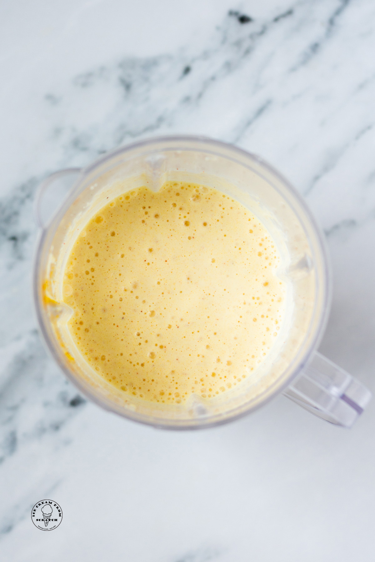 Overhead view of a pineapple milkshake in a blender jar