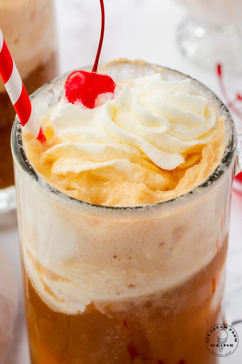 closeup view of a root beer float in a frosted mug.