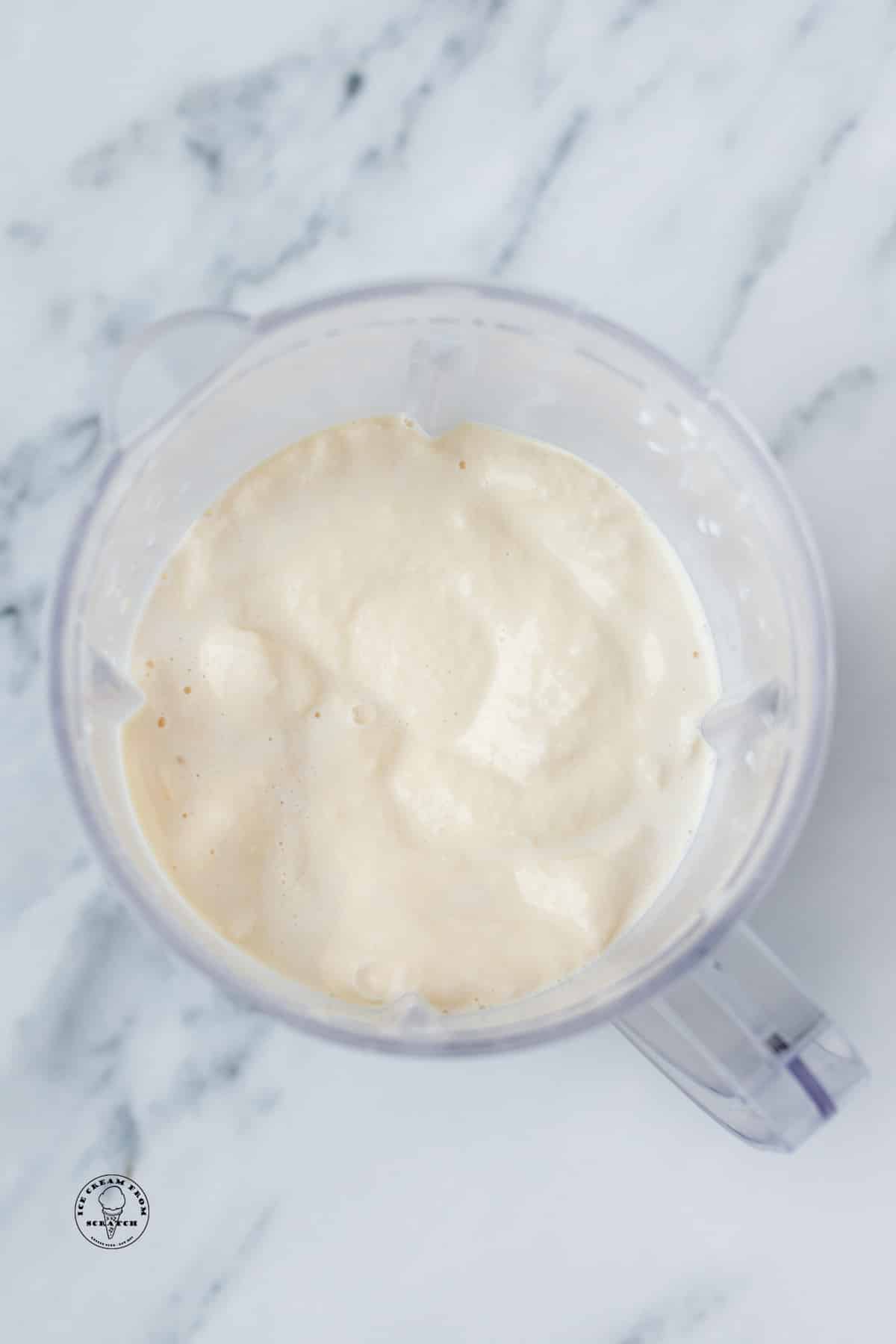 a creamy blended vanilla milkshake in a blender, viewed from above