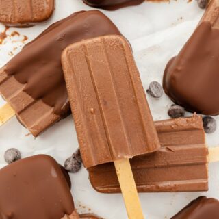 Chocolate ice cream bars, some dipped in chocolate coating, arranged on a tray, viewed from overhead.