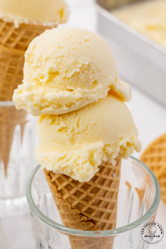 smooth, cream-colored mascarpone ice cream, two scoops on top of a sugar cone that is propped up in a glass.