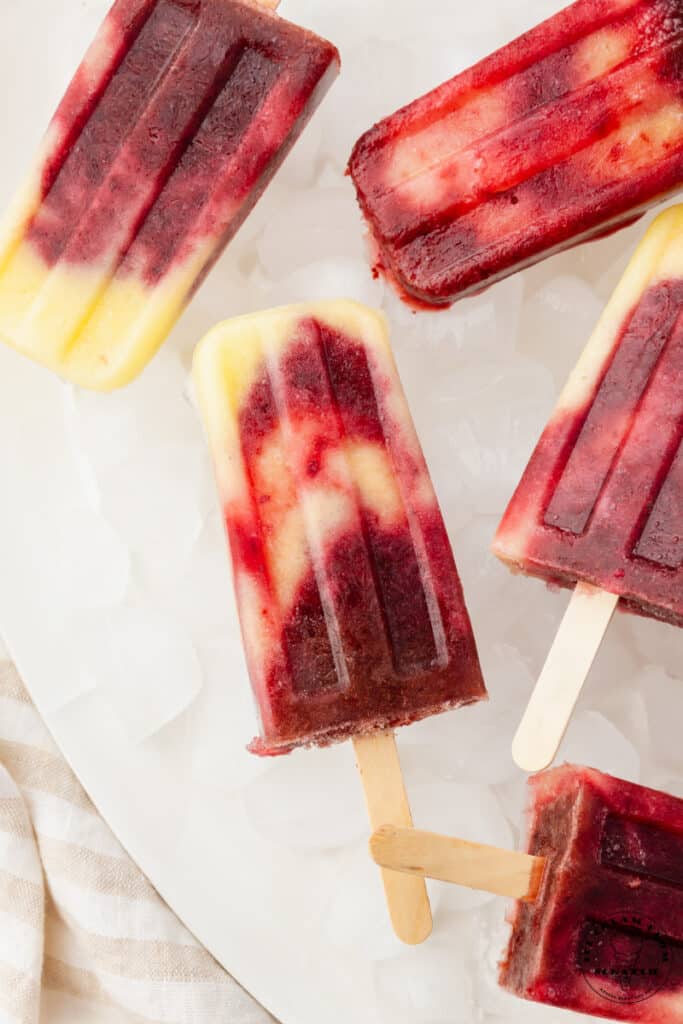 swirled pineapple cherry popsicles on ice.