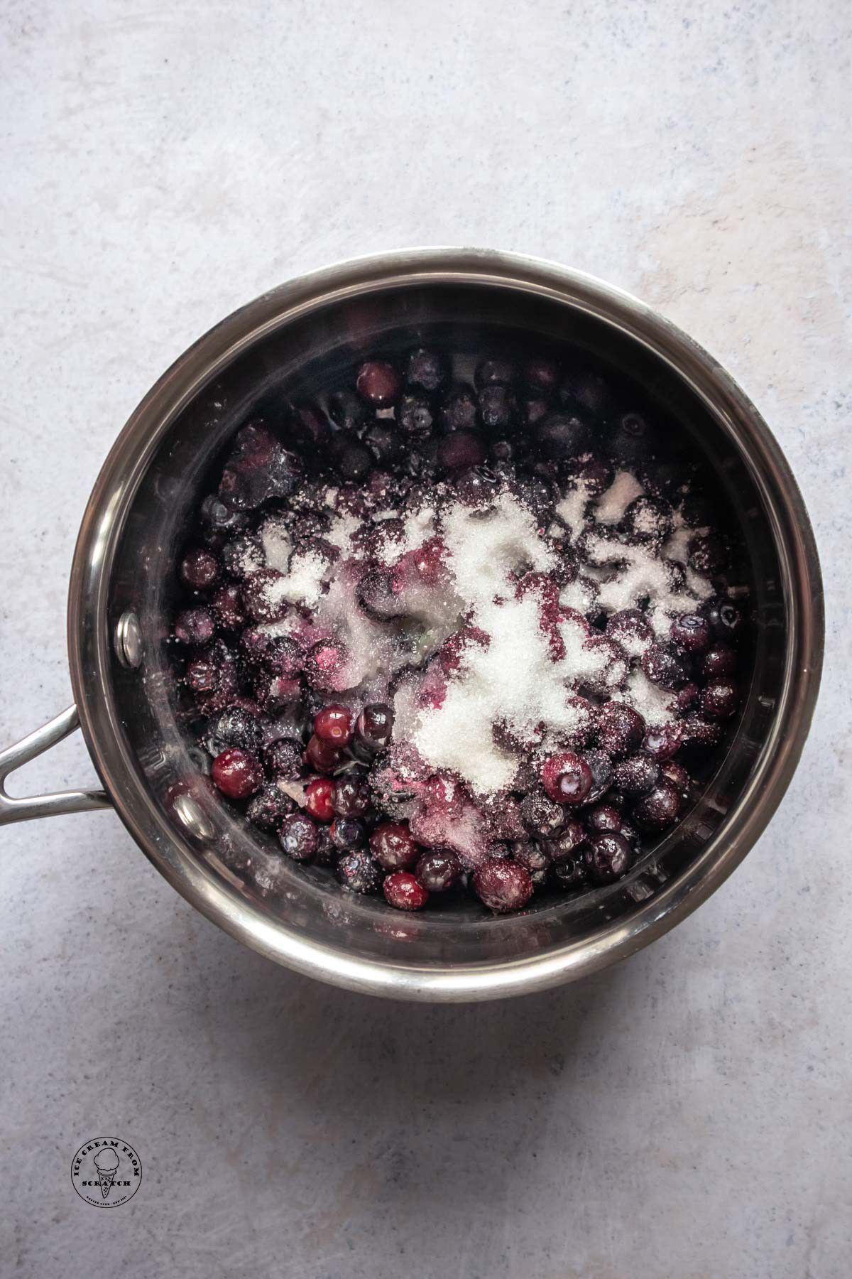 Blueberries and sugar in a small saucepan.