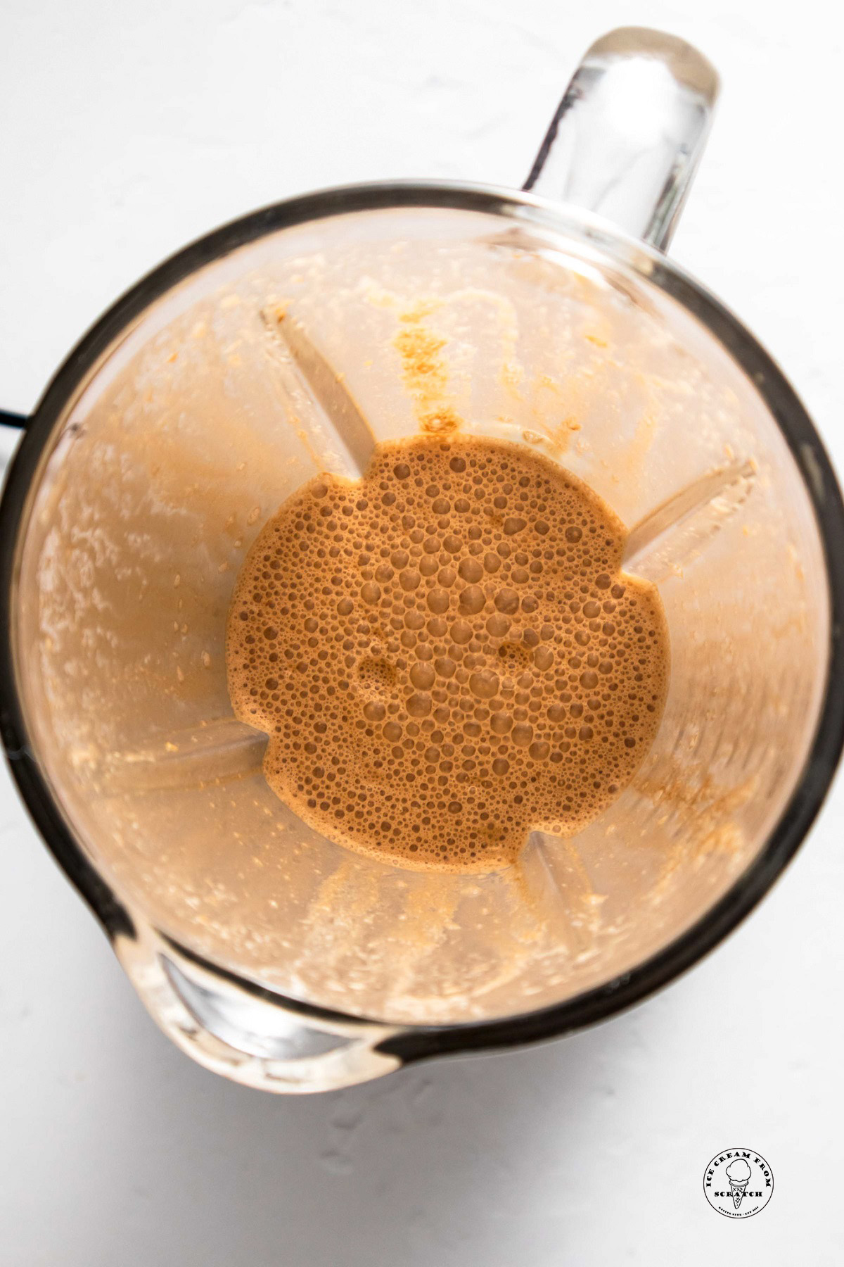 View of a blended coffee milkshake in a blender, from above.
