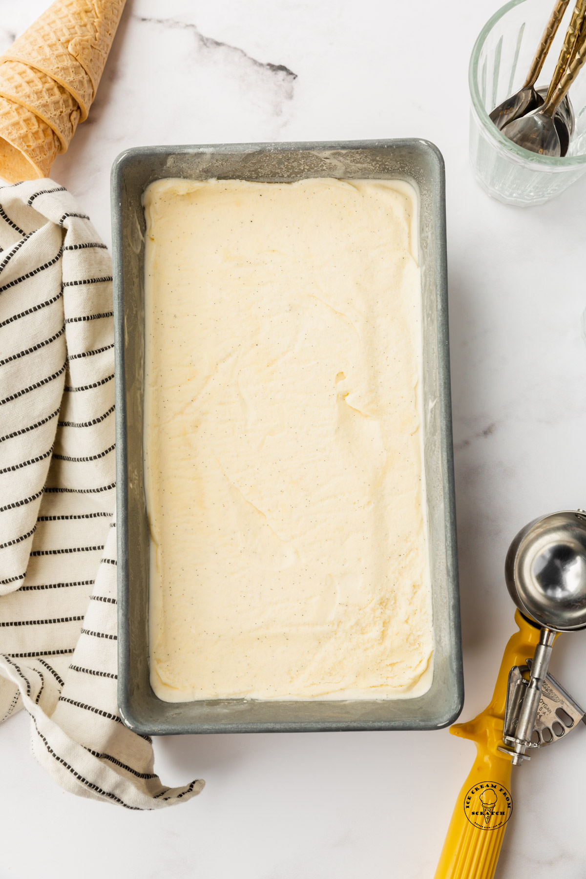 Creamy vanilla custard ice cream in a metal loaf pan.