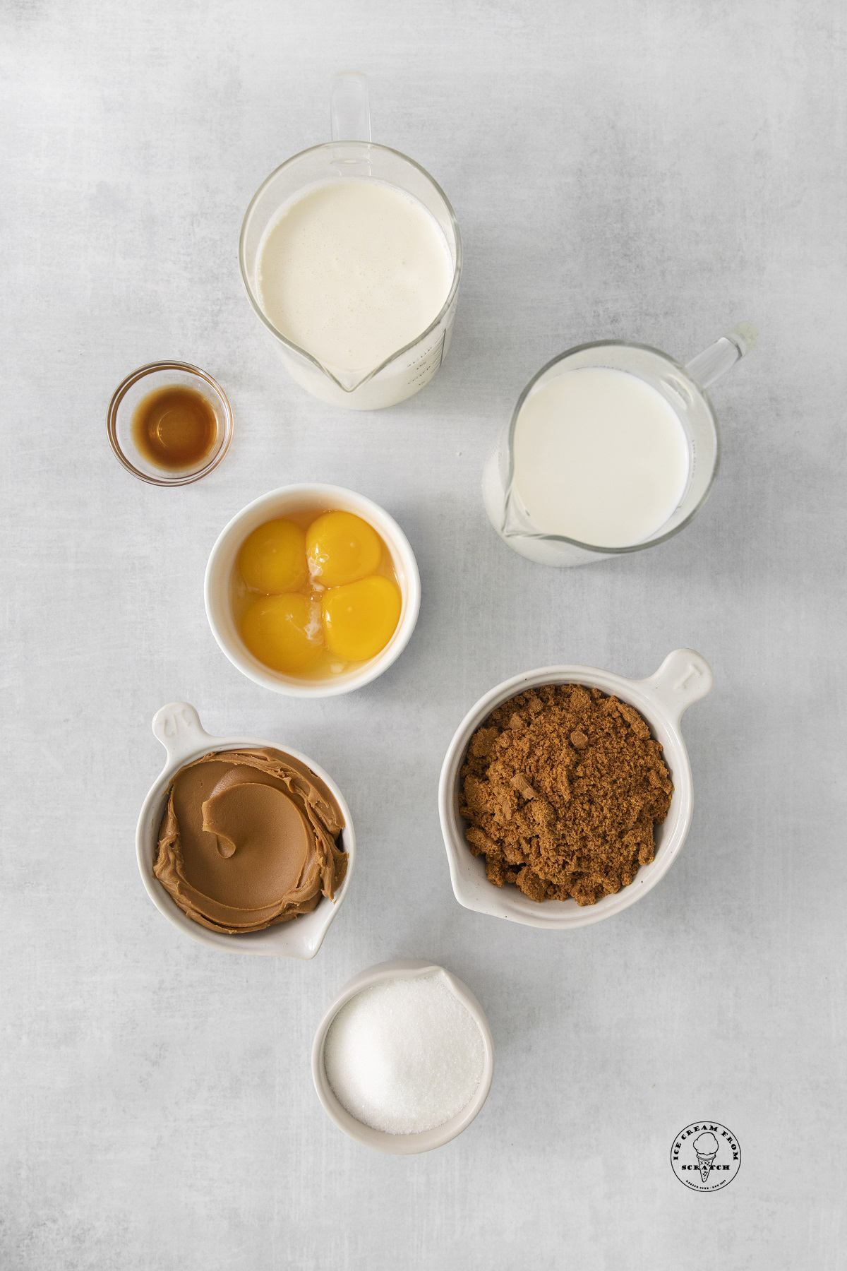 The ingredients needed to make biscoff ice cream, including crushed cookies and cookie butter.