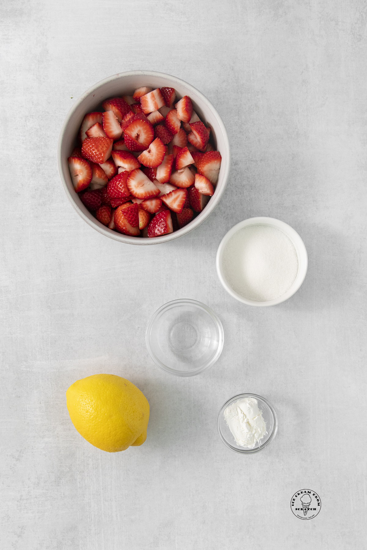 the ingredients for the strawberry compote, including fresh berries, sugar and lemon.