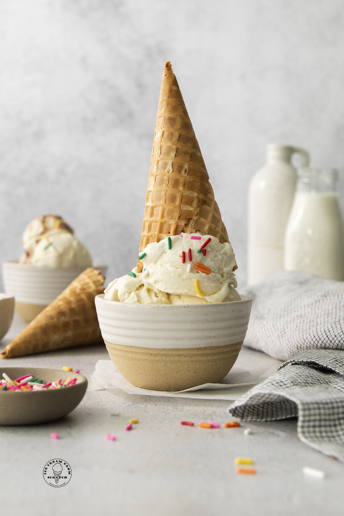 a vanilla ice cream cone turned upside down in a small bowl. 