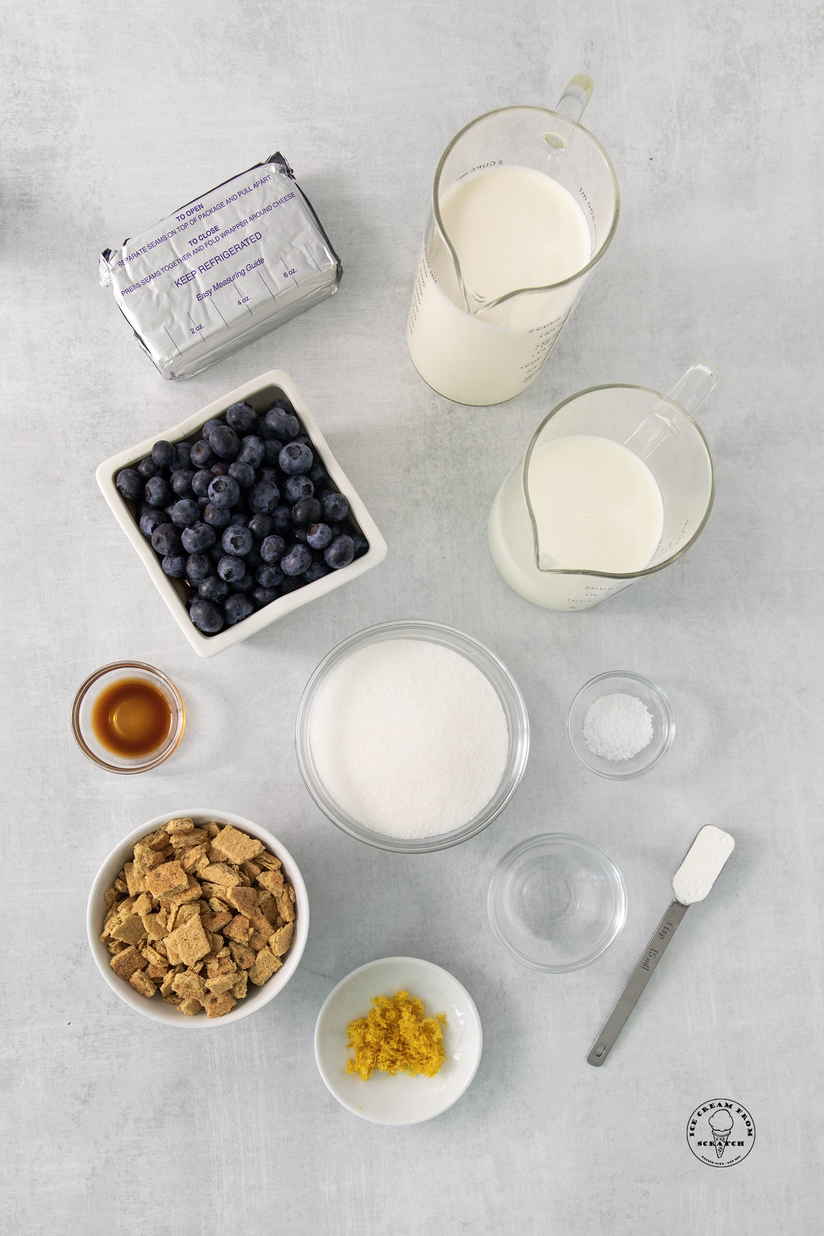 The ingredients for homemade blueberry cheesecake ice cream, all measured and arranged on a counter.