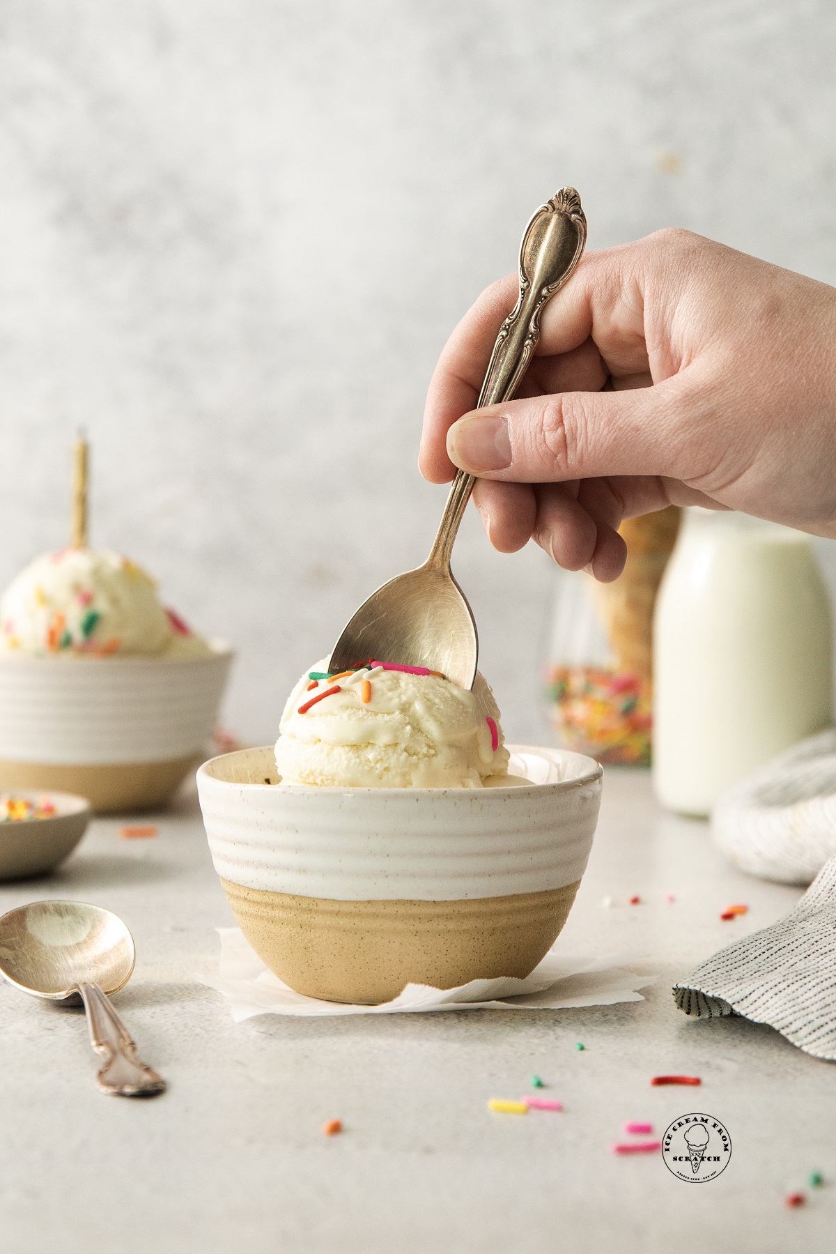 a hand holding a vintage spoon, digging into a bowl of homemade cake batter ice cream