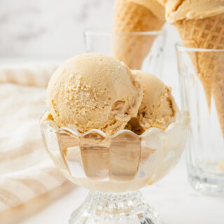 a footed glass bowl of homemade caramel ice cream