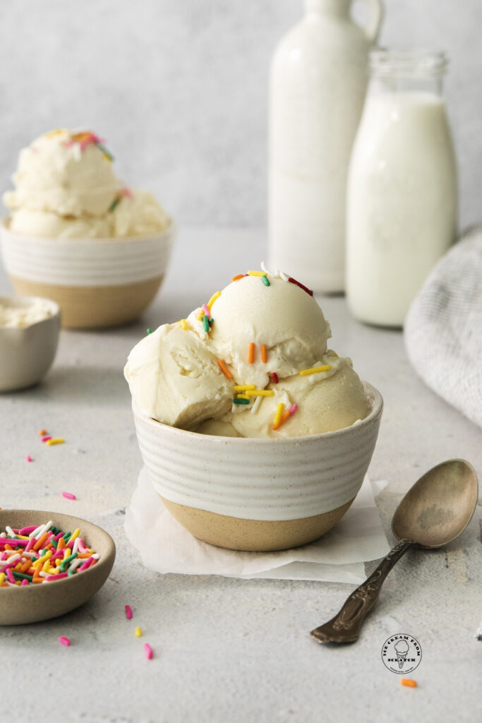a ceramic bowl holding three scoops of protein ice cream topped with sprinkles.