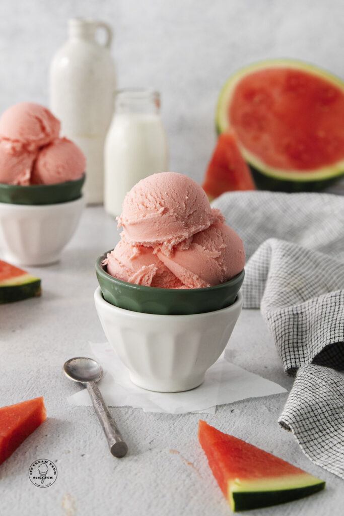a bowl of homemade watermelon ice cream. Milk and fresh watermelon are in the background.