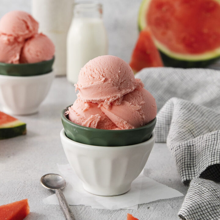 a bowl of homemade watermelon ice cream. Milk and fresh watermelon are in the background.