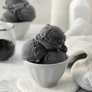 Black ice cream scoops in a white bowl.
