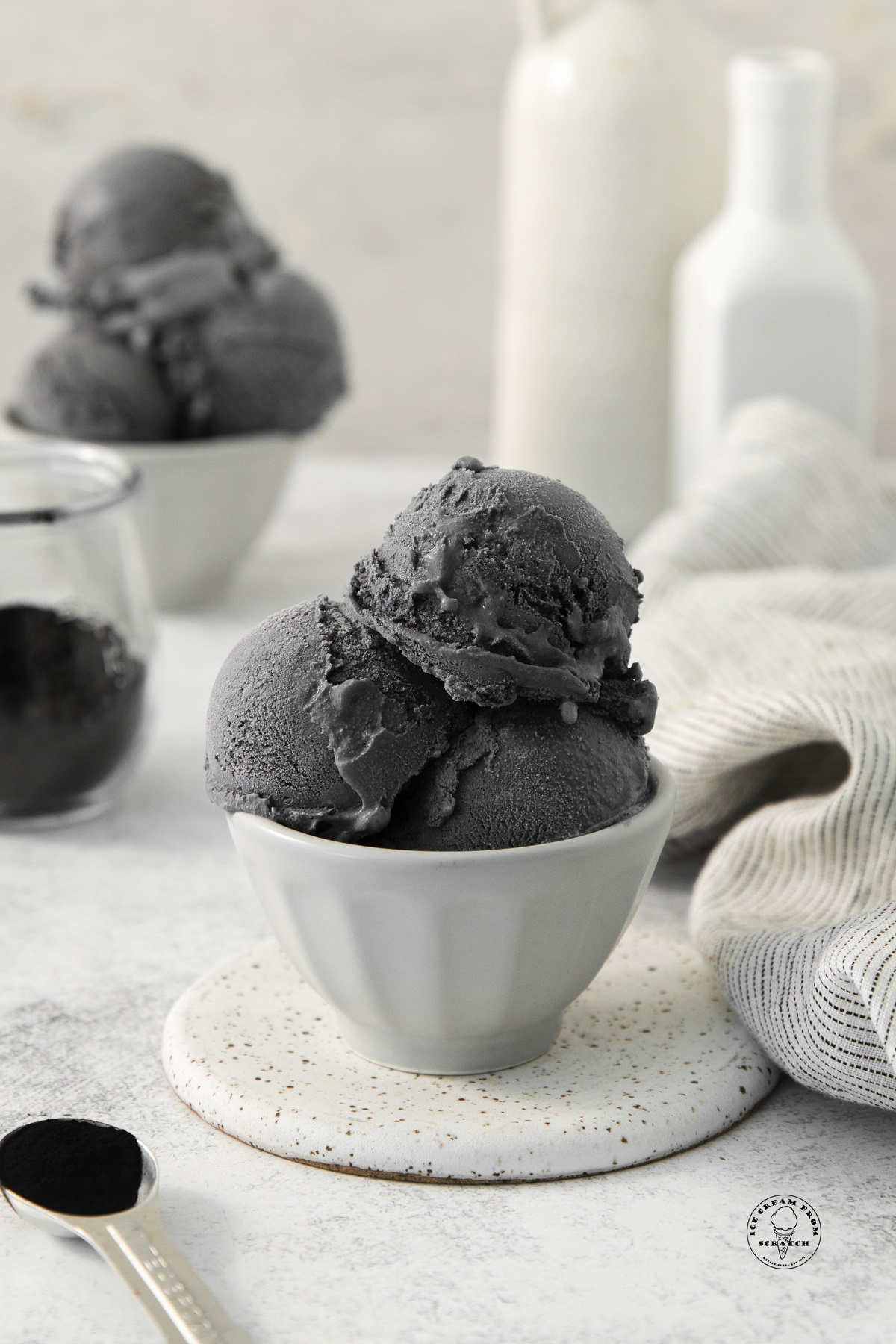 Black ice cream scoops in a white bowl.