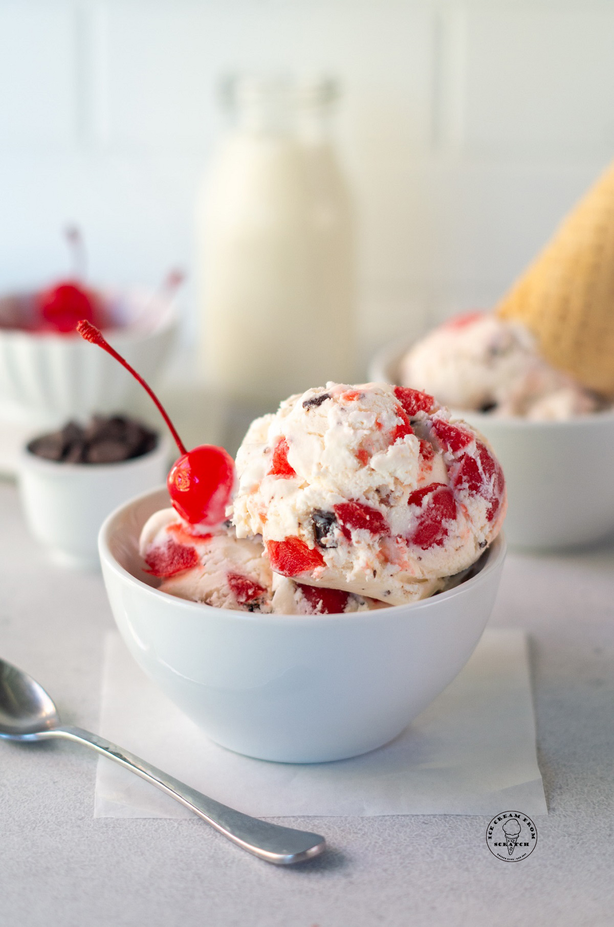 A bowl of homemade cherry cordial ice cream with a cherry on top
