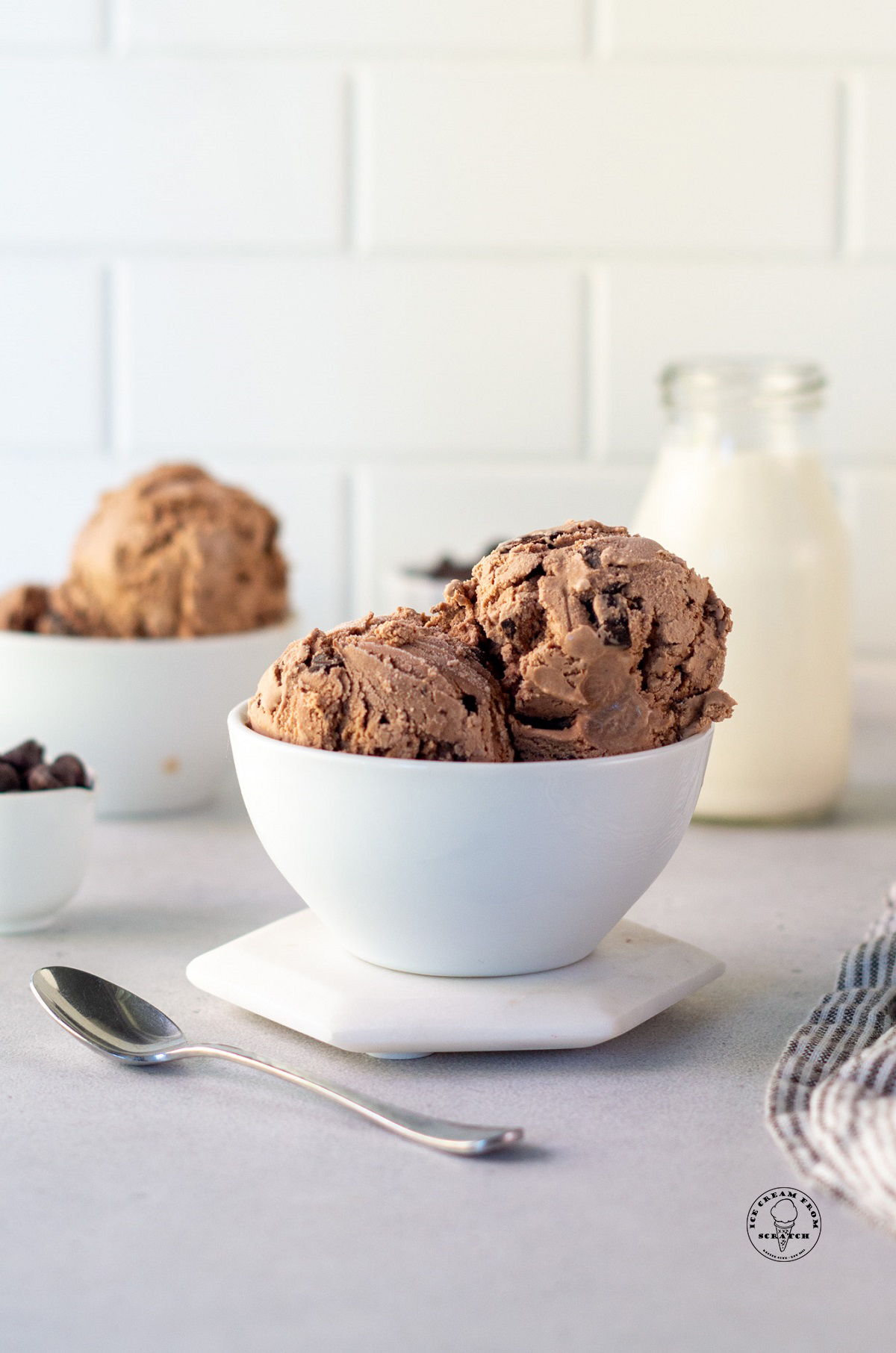 a white bowl holding scoops of homemade chocolate chocolate chip ice cream